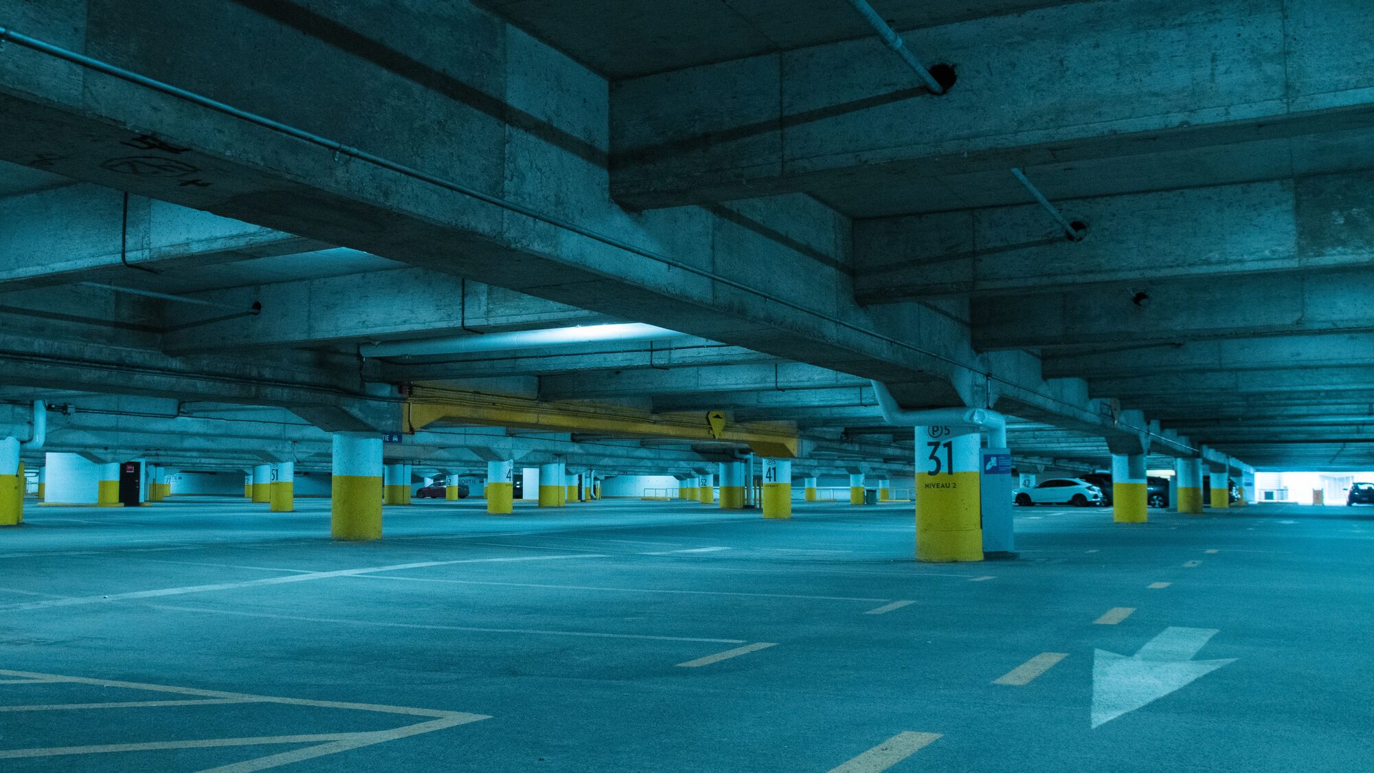 An empty covered parking deck with painted columns